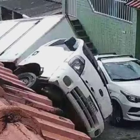 CAMINHÃO TOMBA EM LADEIRA E ATINGE TÁXI E MURO DE CASA